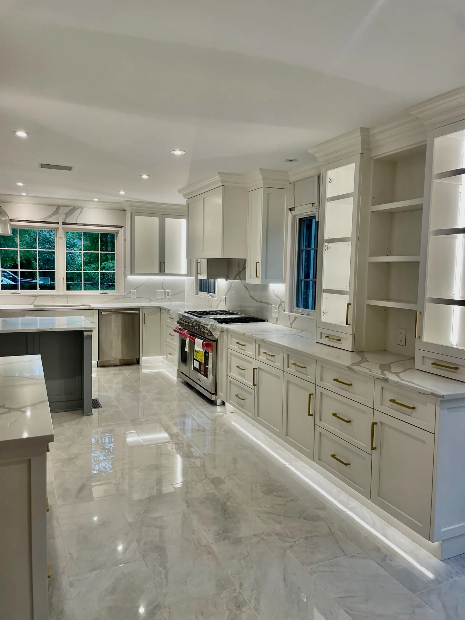 Custom white and gray kitchen remodel with large island and built-in cabinetry